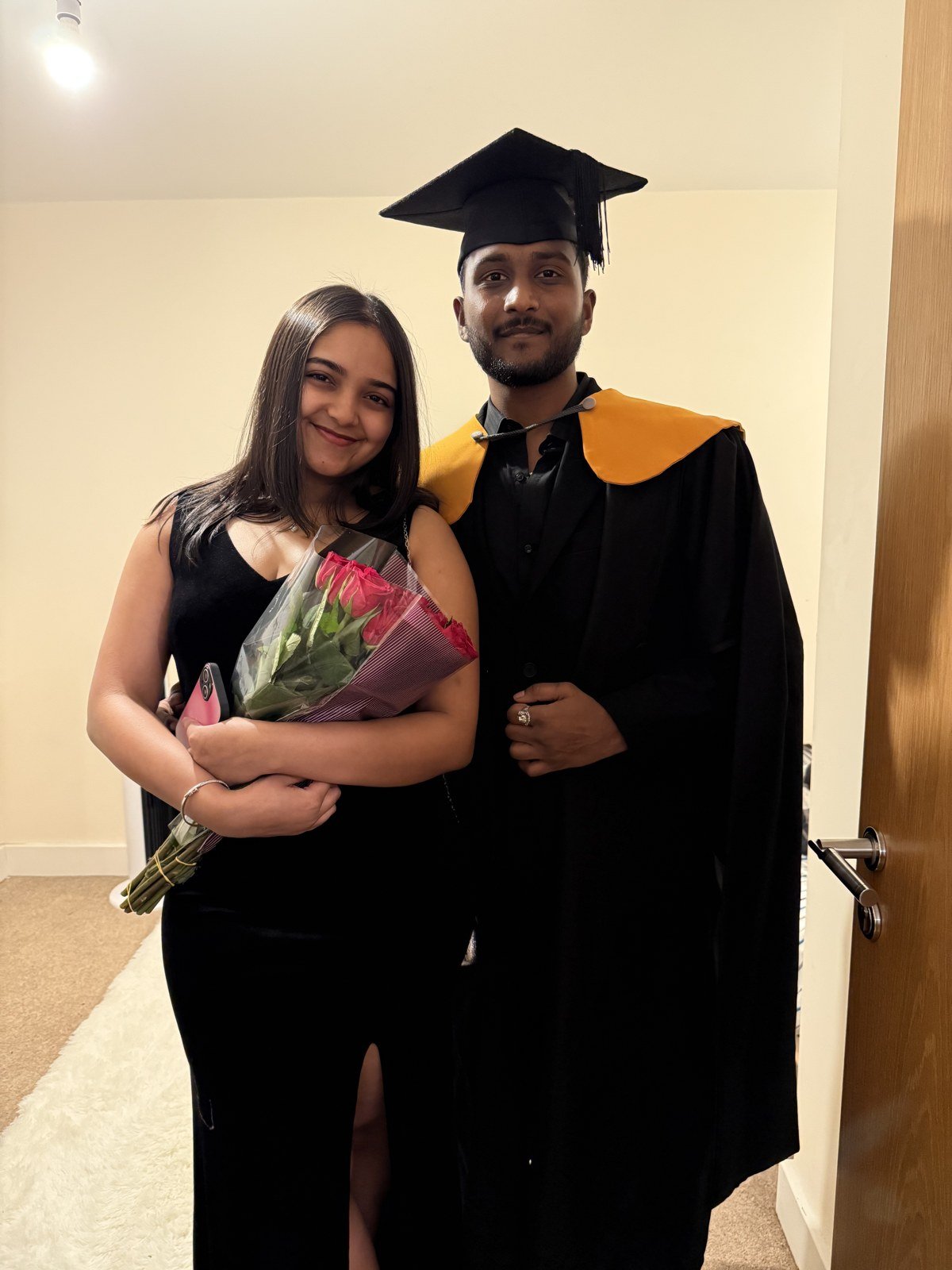 Akash in graduation attire with his girlfriend